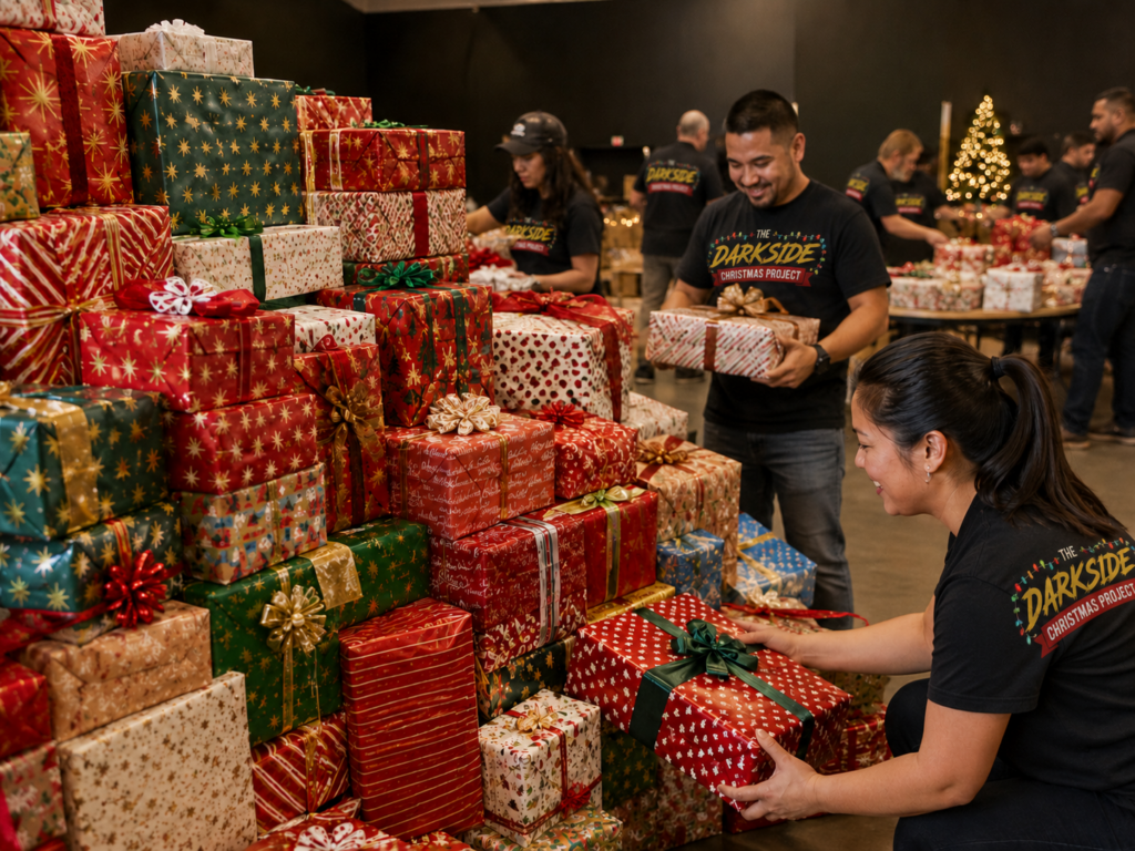 Volunteers wearing Dark Side Christmas Project shirts preparing wrapped Christmas gifts